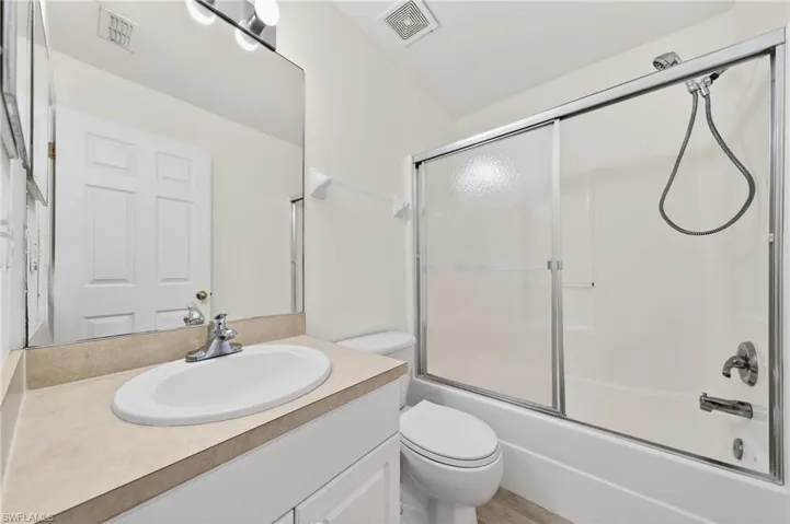 Full bathroom featuring vanity and bath / shower combo with glass door