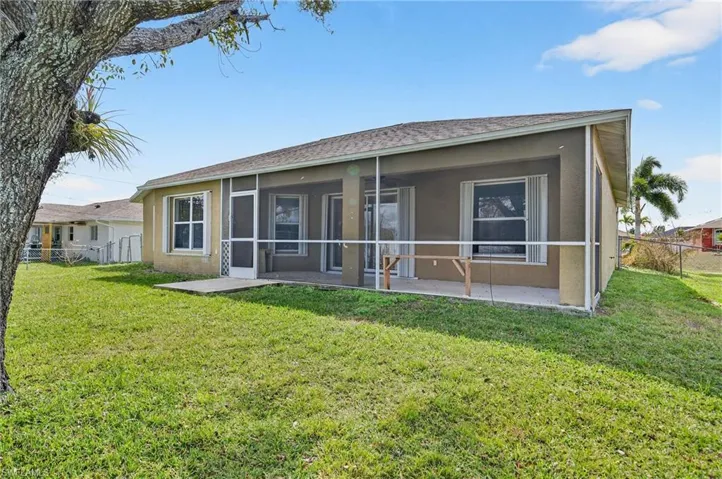 Back of property with a fenced backyard, stucco siding, and a sunroom