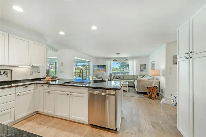 Kitchen featuring stainless steel dishwasher, a sink, light wood-style flooring, recessed lighting, and a peninsula