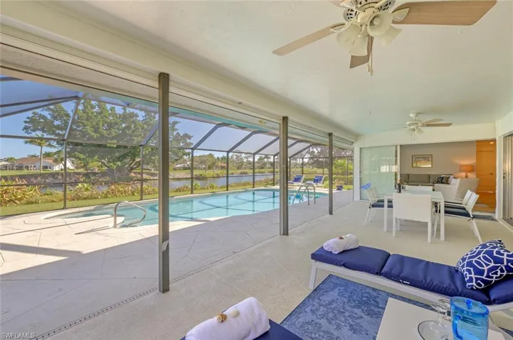 Swimming pool featuring a ceiling fan, a patio area, an outdoor hangout area, and a water view