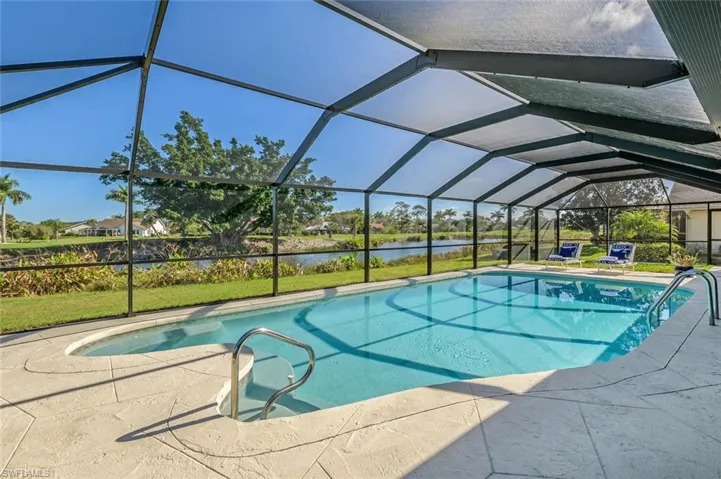 Swimming pool featuring a water view, a patio area, and glass enclosure