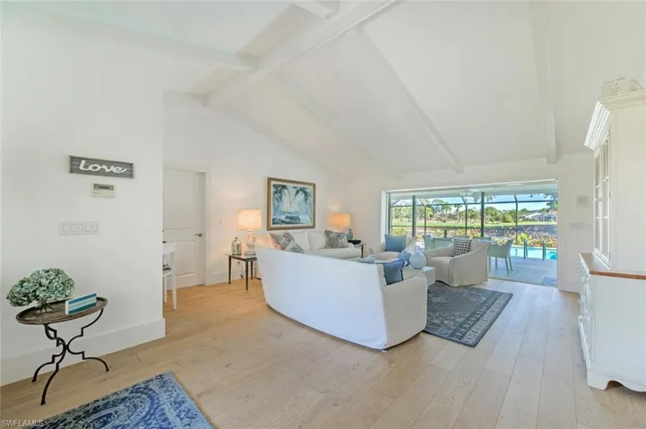 Living area featuring light wood-style flooring, a sunroom, and baseboards