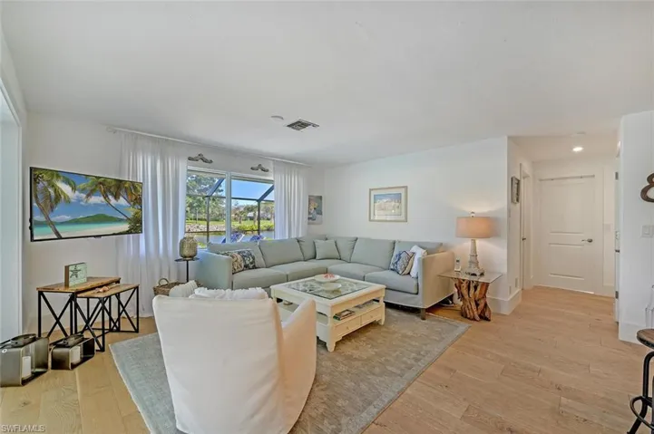 Living room with light wood-style flooring and recessed lighting