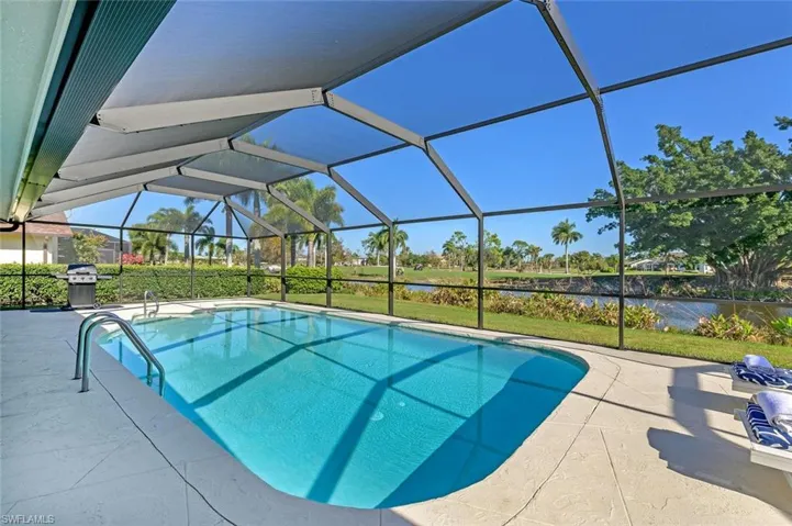 Outdoor pool featuring a patio area, a water view, and a lanai