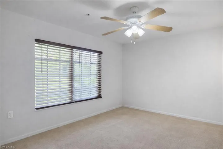 Spare room featuring light carpet and ceiling fan