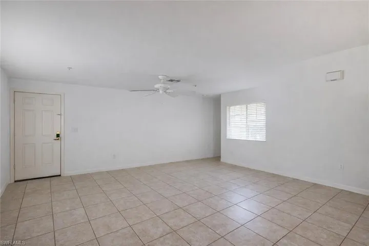 Unfurnished room featuring ceiling fan, light tile patterned floors, and cooling unit