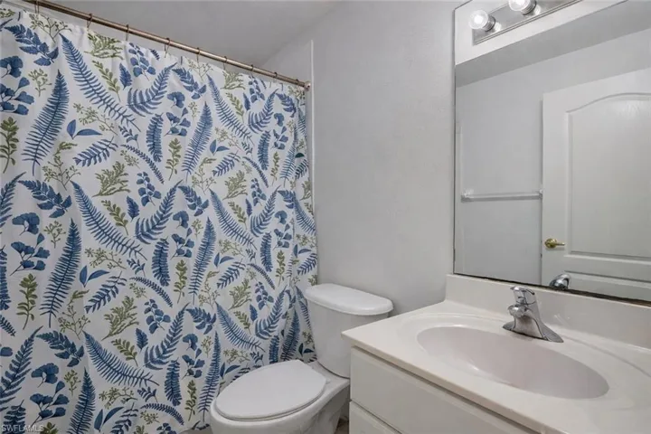 Spare room featuring plenty of natural light, ceiling fan, and light carpet