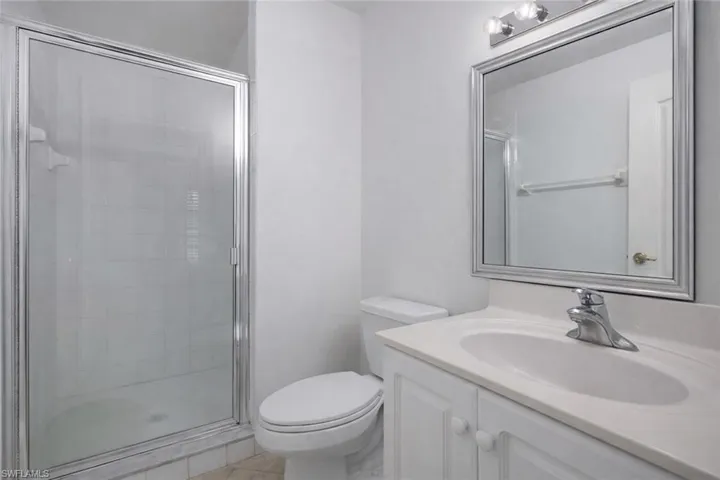 Bathroom with vanity, a stall shower, and light tile patterned flooring
