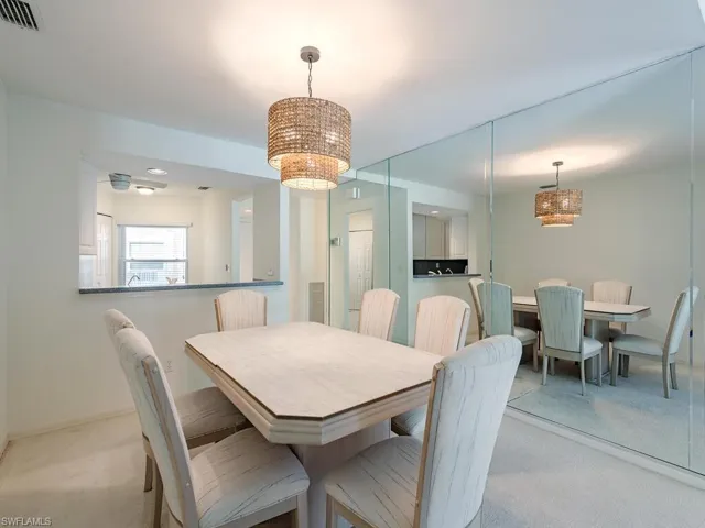 Carpeted dining room featuring a notable chandelier