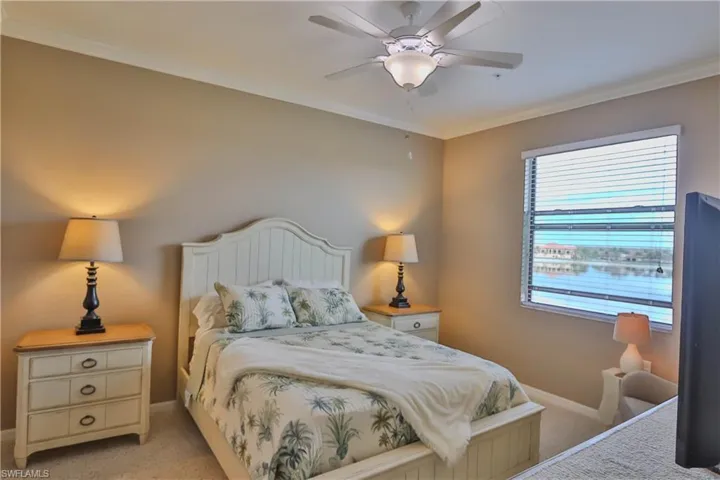 Bedroom featuring light carpet, crown molding, and ceiling fan