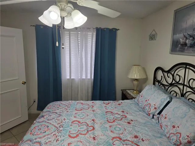 Tiled bedroom featuring a ceiling fan