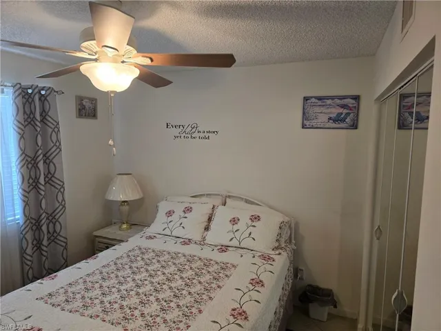 Bedroom with a closet, a textured ceiling, and visible vents
