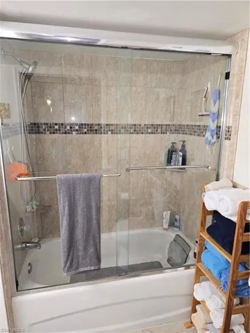 Bathroom with combined bath / shower with glass door