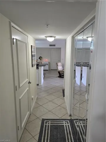 Hall featuring baseboards, visible vents, and light tile patterned floors
