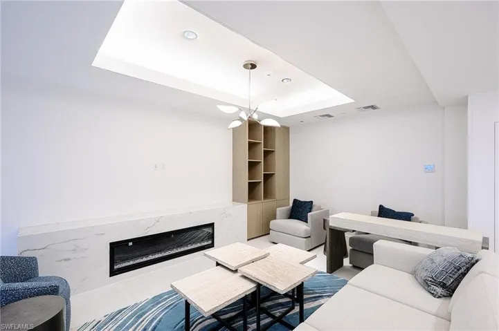 Living area with a tray ceiling, a fireplace, and recessed lighting