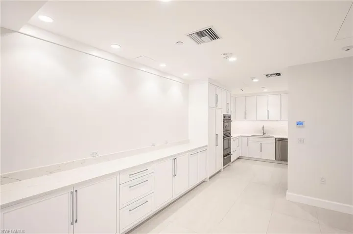 Kitchen featuring white cabinetry, light stone counters, recessed lighting, light tile patterned flooring, and stainless steel appliances