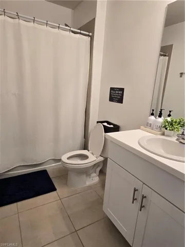 Bathroom with tile patterned flooring, vanity, and toilet
