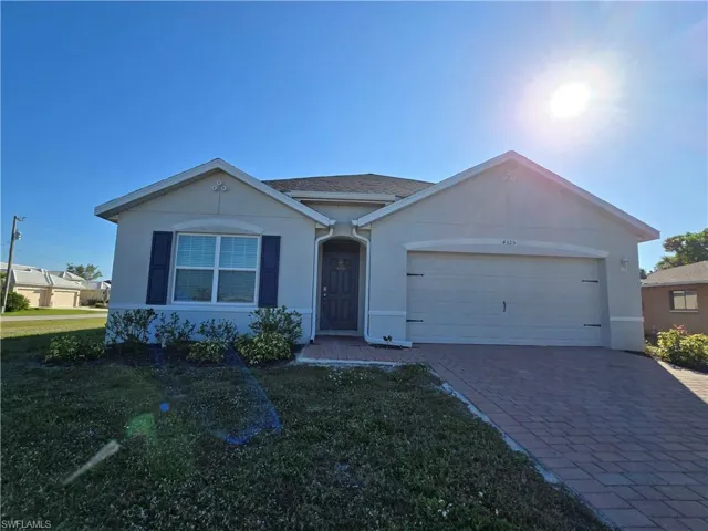 Single story home with a garage and a front yard