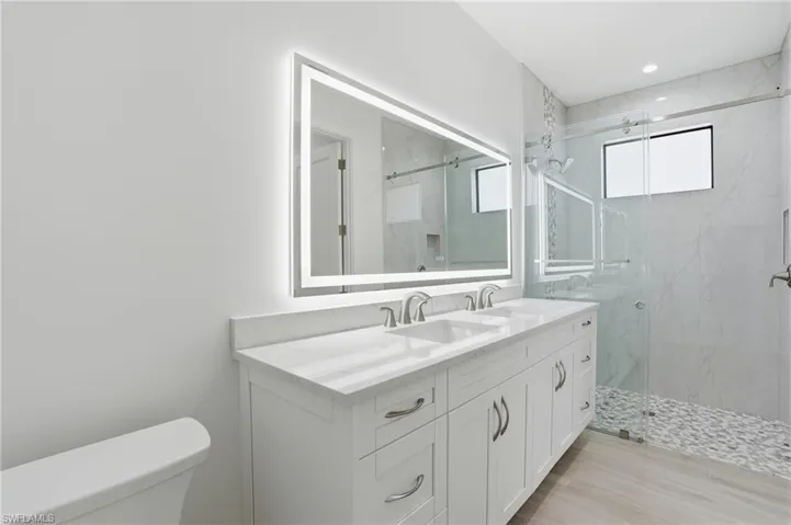 Primary bathroom featuring dual sinks and a walk-in shower