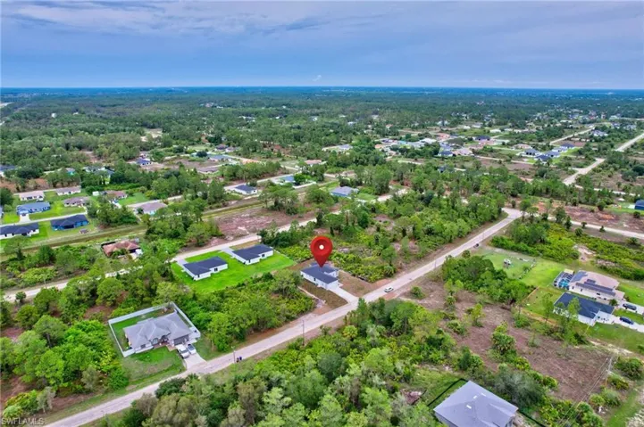 Aerial view of property and surrounding area featuring nearby suburban area