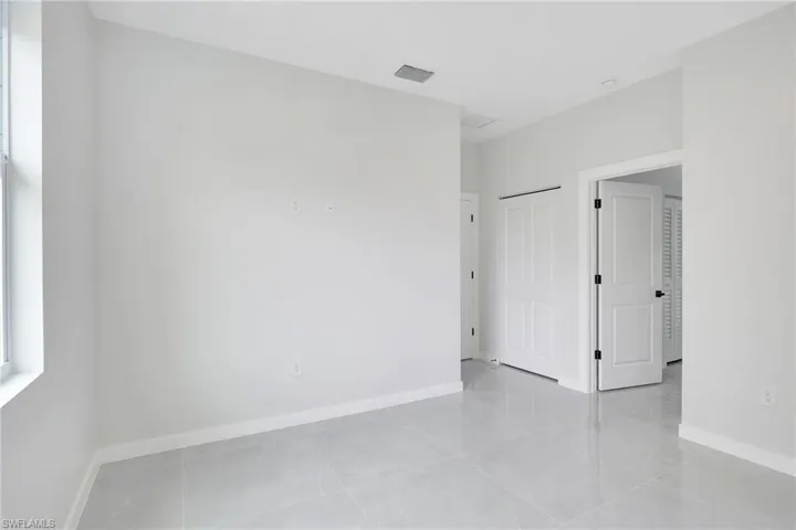 Empty room featuring baseboards and light tile patterned floors