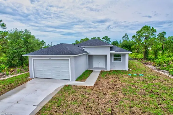 Ranch-style house with driveway, stucco siding, a garage, and a shingled roof