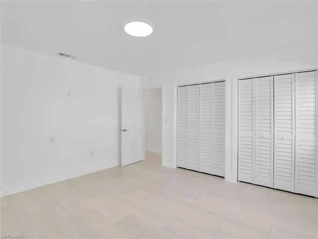Unfurnished bedroom featuring multiple closets