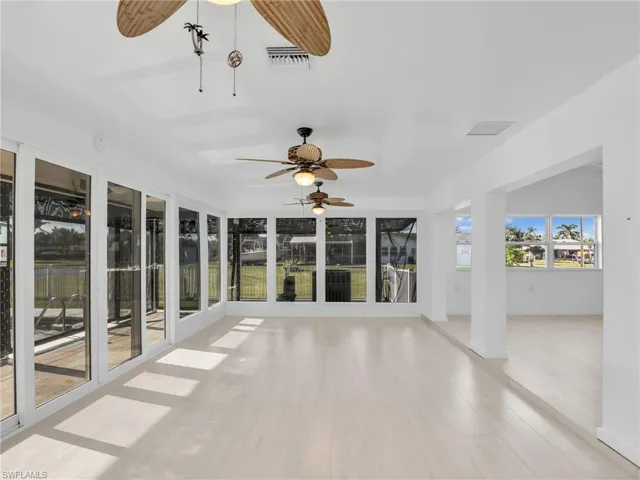 Unfurnished sunroom featuring ceiling fan