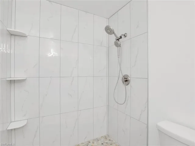 Bathroom with tiled shower and toilet