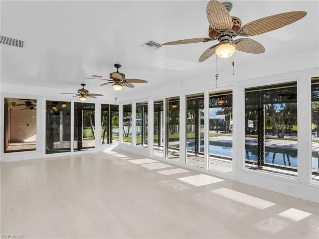 Unfurnished sunroom featuring ceiling fan
