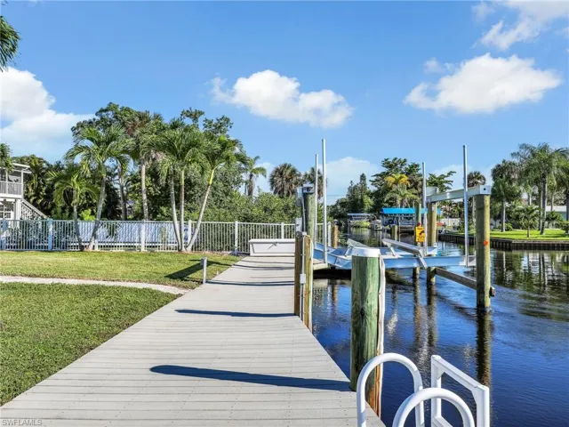 Dock area with a lawn and a water view