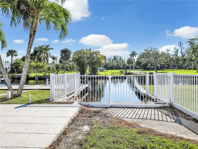 View of dock with a lawn and a water view