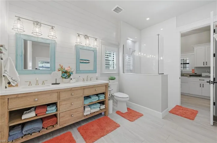 Bathroom with double vanity, walk in shower, and recessed lighting