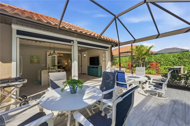 Deck with outdoor dining space, a patio area, a sunroom, and a lanai