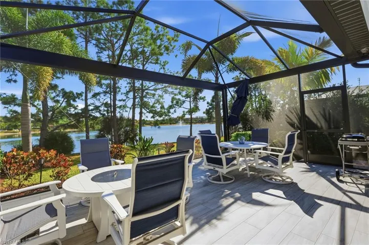 View of patio / terrace with outdoor dining space, a lanai, a sunroom, area for grilling, and a water view