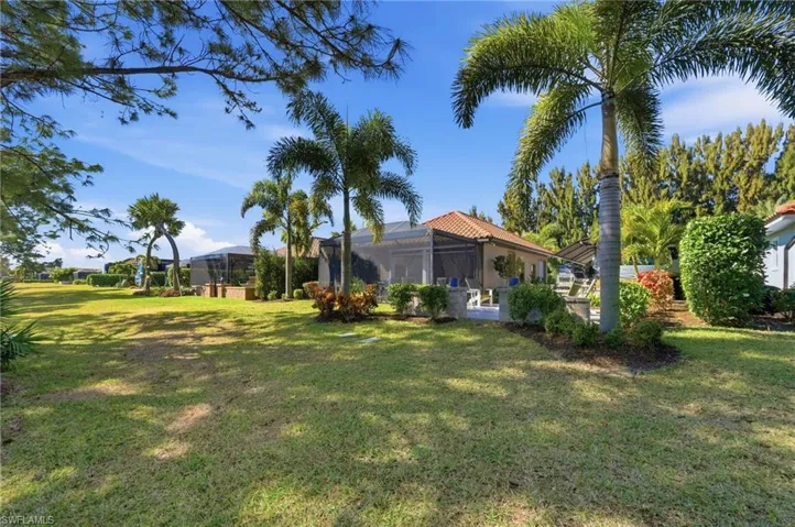 View of grassy yard featuring a sunroom and a lanai