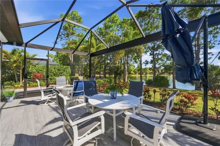 View of patio / terrace with glass enclosure, a water view, a sunroom, and outdoor dining area