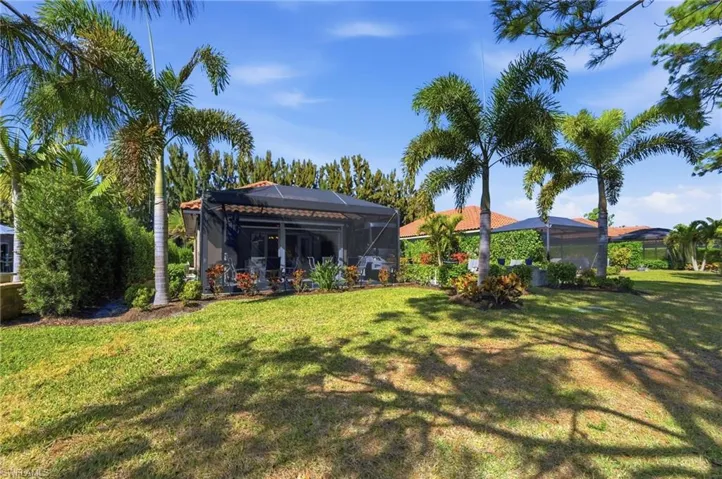 Rear view of property featuring a lanai, a lawn, and a sunroom