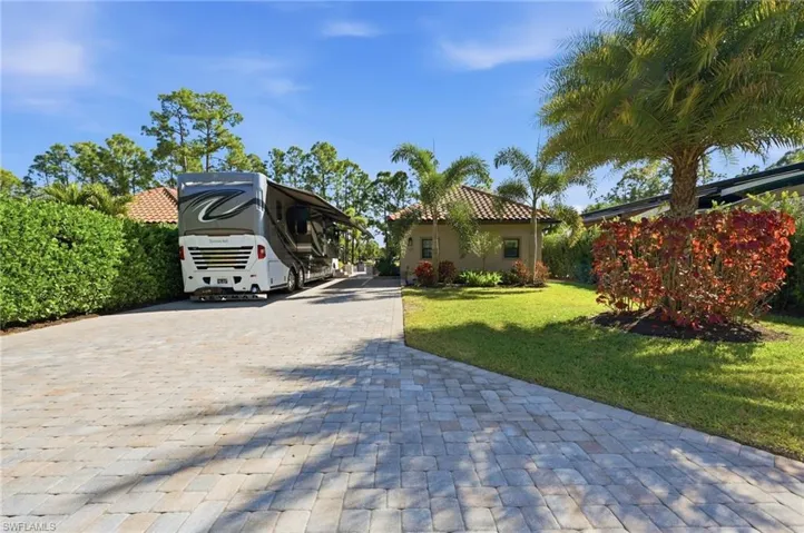 Mediterranean / spanish-style house with a front yard, decorative driveway, and stucco siding