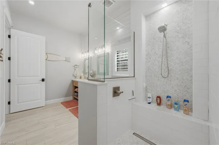 Bathroom with walk in shower, light wood finished floors, vanity, and recessed lighting