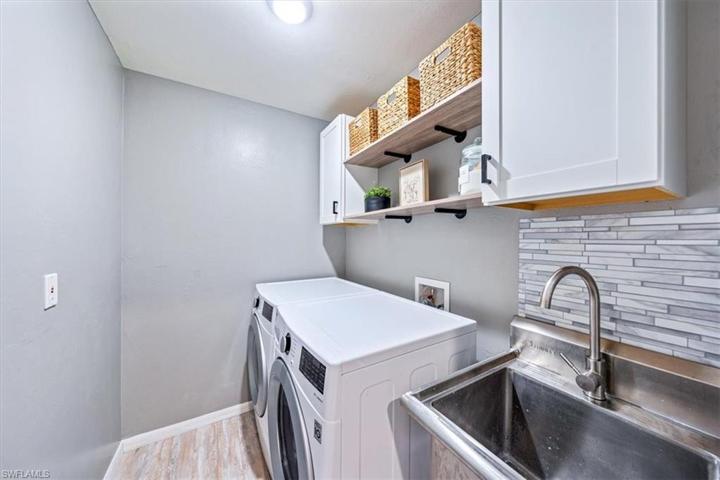 The updated laundry room included upper cabinets, floating shelves, and a new stainless steel laundry sink.