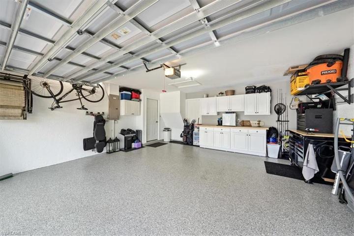 Upgraded epoxy flake floor treatment along with cabinets and shelving set the stage for a tidy and organized garage.