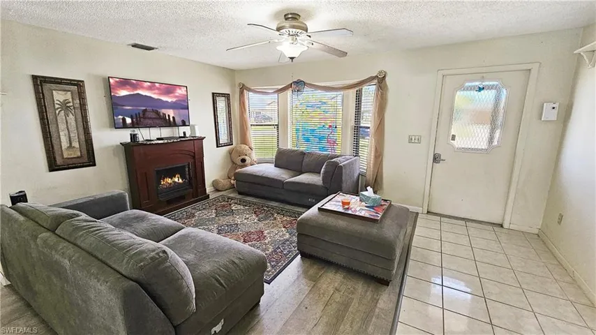 Living room featuring ceiling fan and a textured ceiling