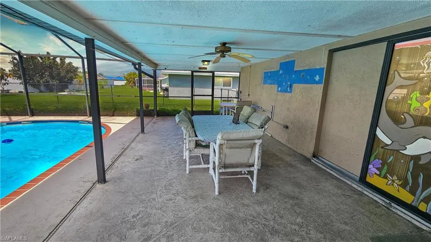 View of pool featuring a patio area, ceiling fan, a lanai, and a lawn