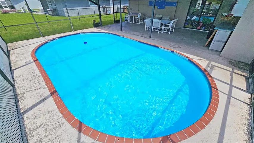 View of swimming pool with a patio area and a lawn