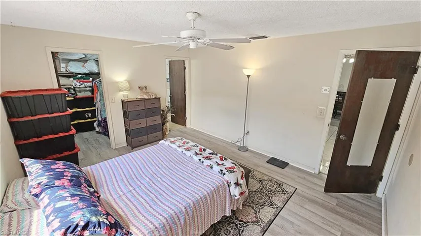 Bedroom featuring ceiling fan, a textured ceiling, and light hardwood / wood-style flooring