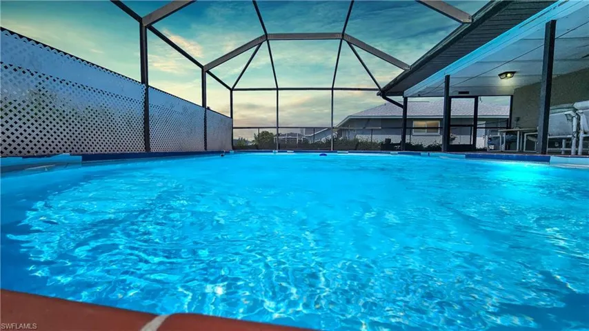 Pool at dusk featuring glass enclosure