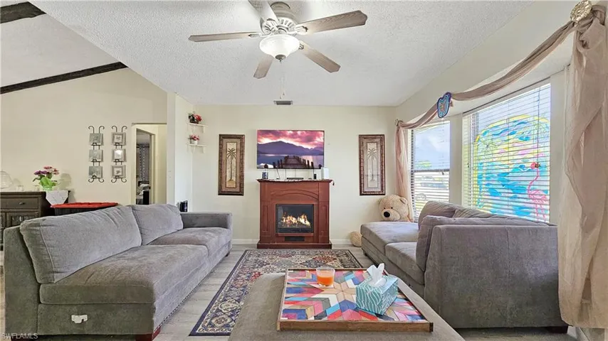Living room with ceiling fan and a textured ceiling