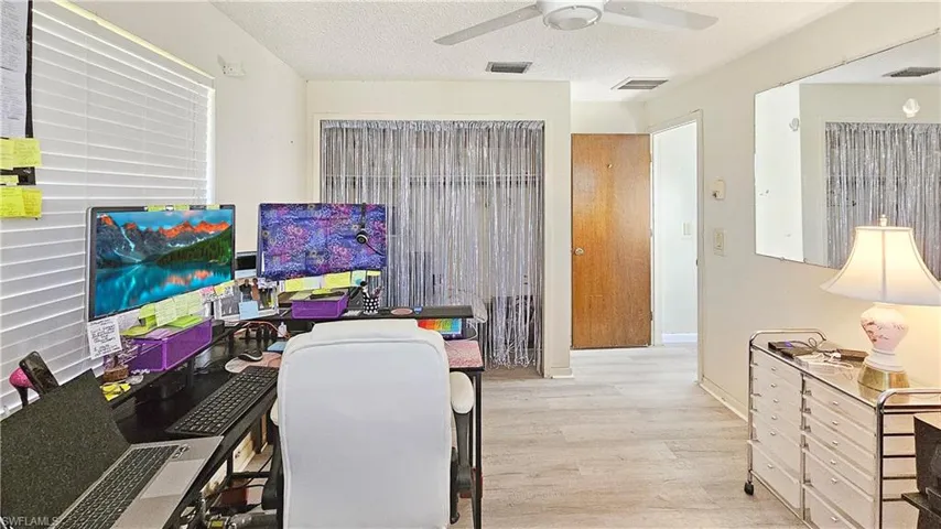 Home office with a textured ceiling, light hardwood / wood-style floors, and ceiling fan
