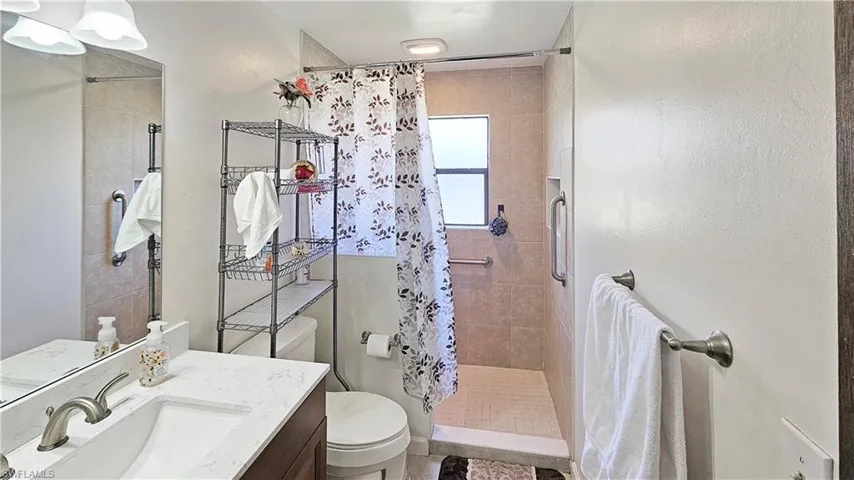 Bathroom with walk in shower, vanity, and toilet